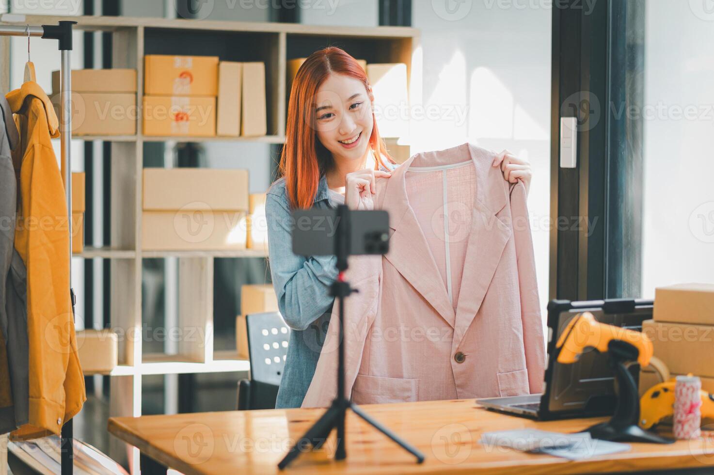 SME owner using the smartphone and tablet for recording . vlog and live stream at her shop,SME business concept, online shopping. photo