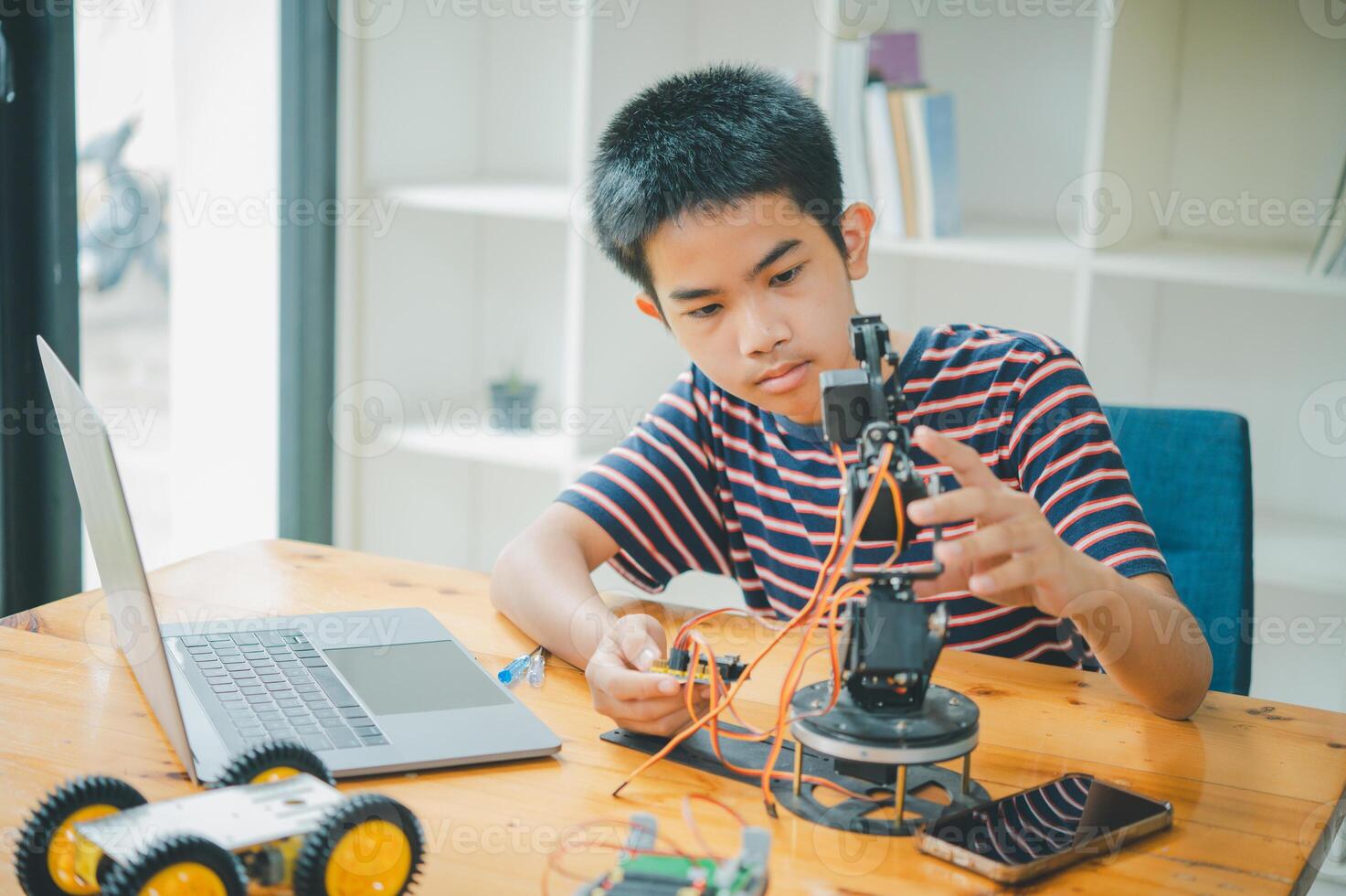 Asian boy learning and studying the work of technology robots.homeschool and science for tech project. playing childhood kids hobby leisure lifestyle people toys robotics technology. photo
