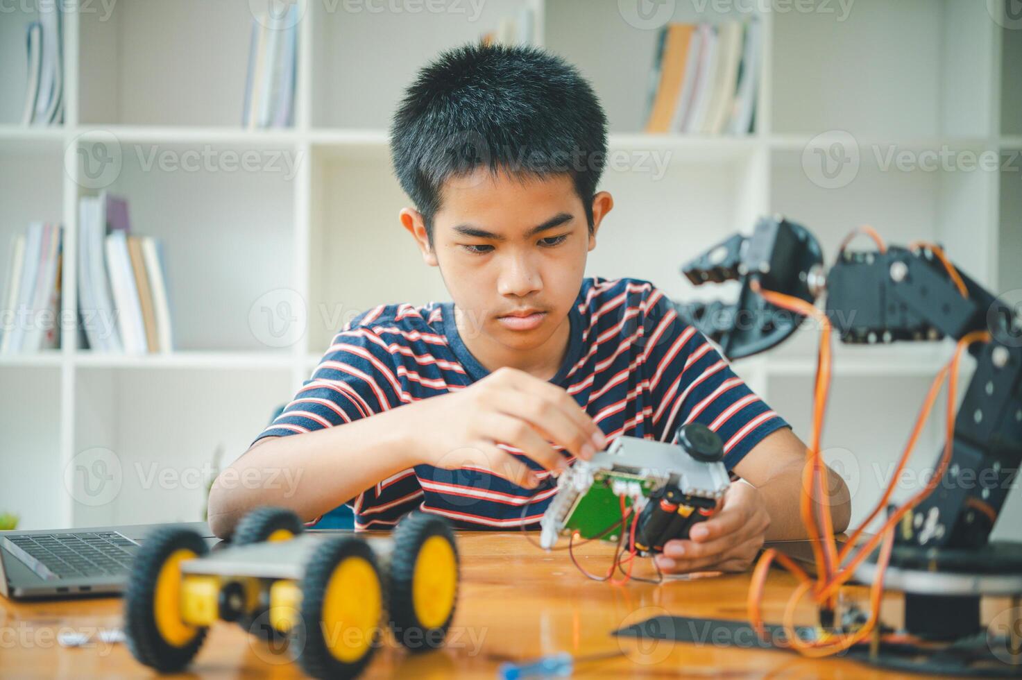Asian boy learning and studying the work of technology robots.homeschool and science for tech project. playing childhood kids hobby leisure lifestyle people toys robotics technology. photo