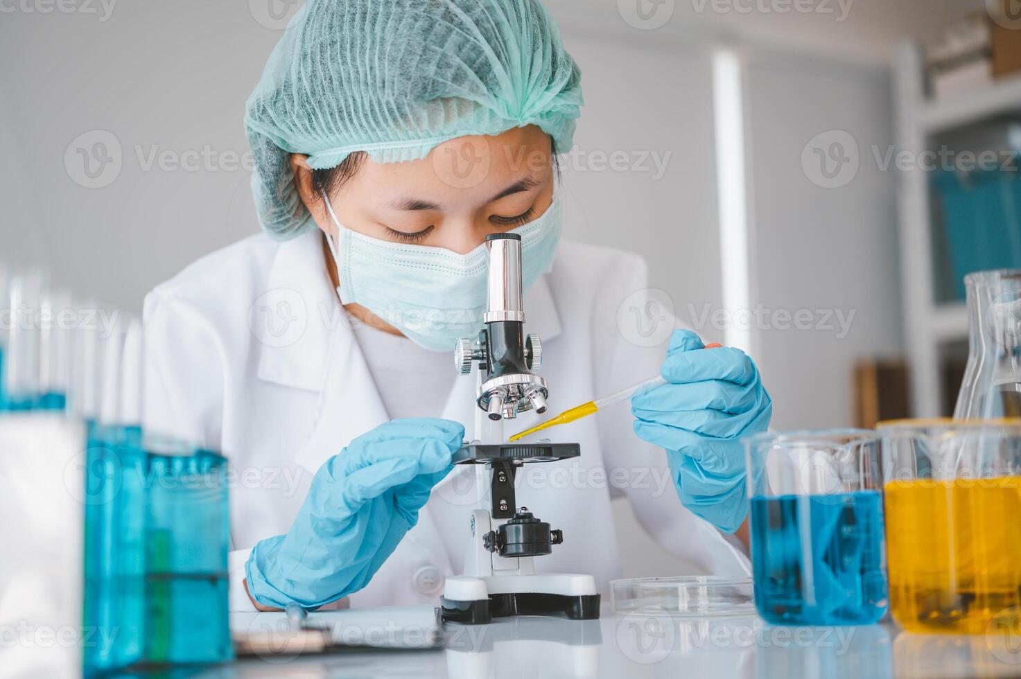 Female researchers are experimenting with pipette dropping a sample into a test tube in an experiment research in laboratory.. photo