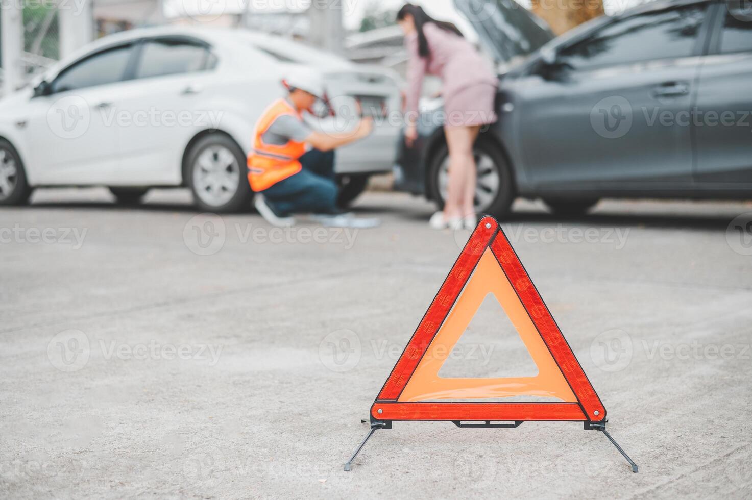 red emergency triangle on the road indicates that there is an accident or car breakdown on the road ahead. photo