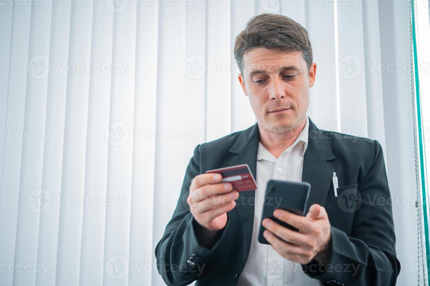 Businessman holds a credit card,unlocking opportunities with digital transactions and savvy financial choices photo
