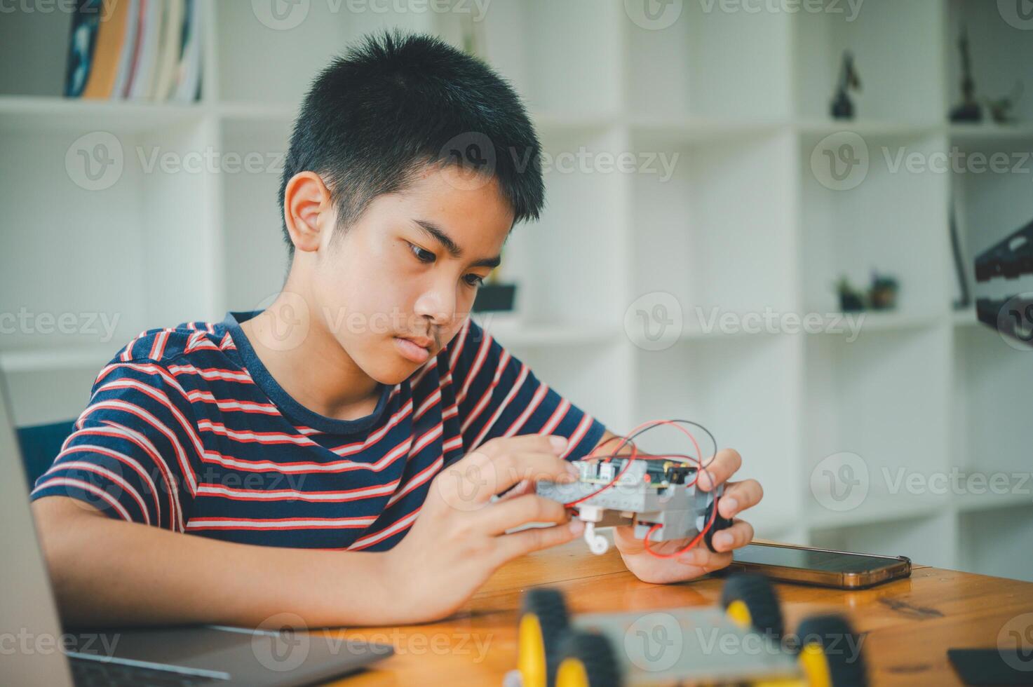 Asian boy learning and studying the work of technology robots.homeschool and science for tech project. playing childhood kids hobby leisure lifestyle people toys robotics technology. photo