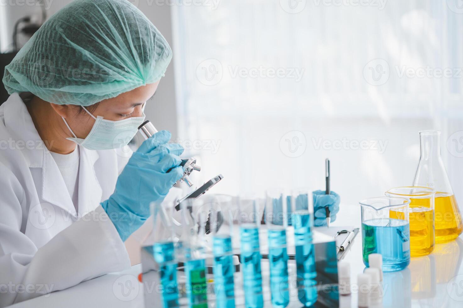 Female researchers are experimenting with pipette dropping a sample into a test tube in an experiment research in laboratory.. photo