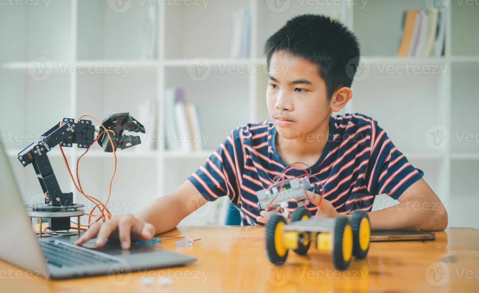Asian boy learning and studying the work of technology robots.homeschool and science for tech project. playing childhood kids hobby leisure lifestyle people toys robotics technology. photo