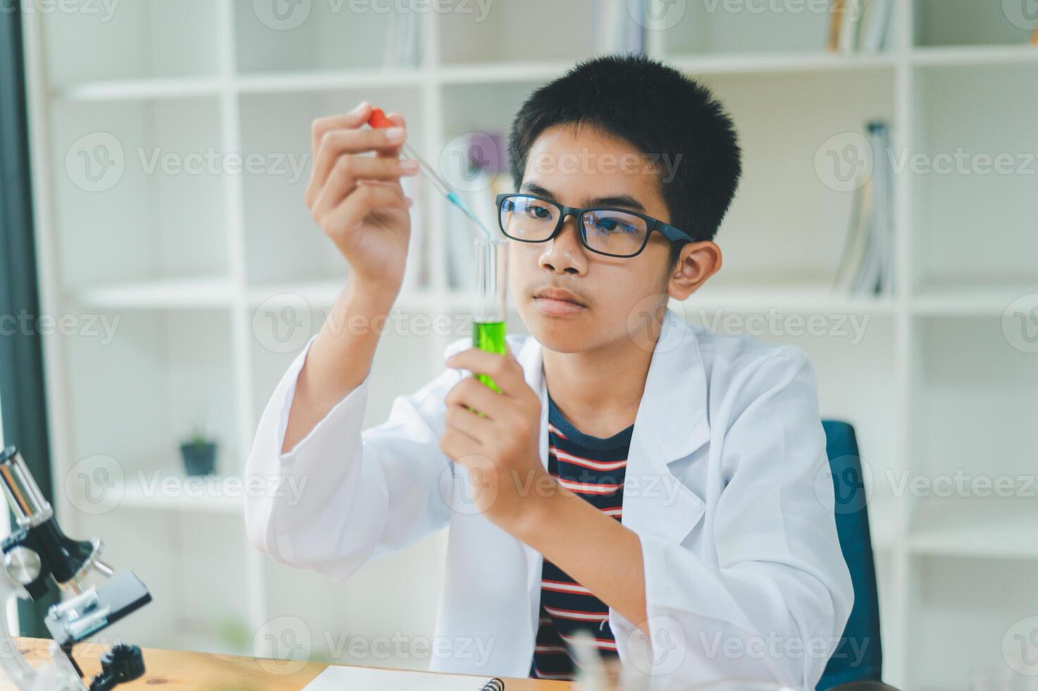 Asian male science students looking through a microscope and tests of plants in the classroom. Learning about scientific experiments on plant species. photo