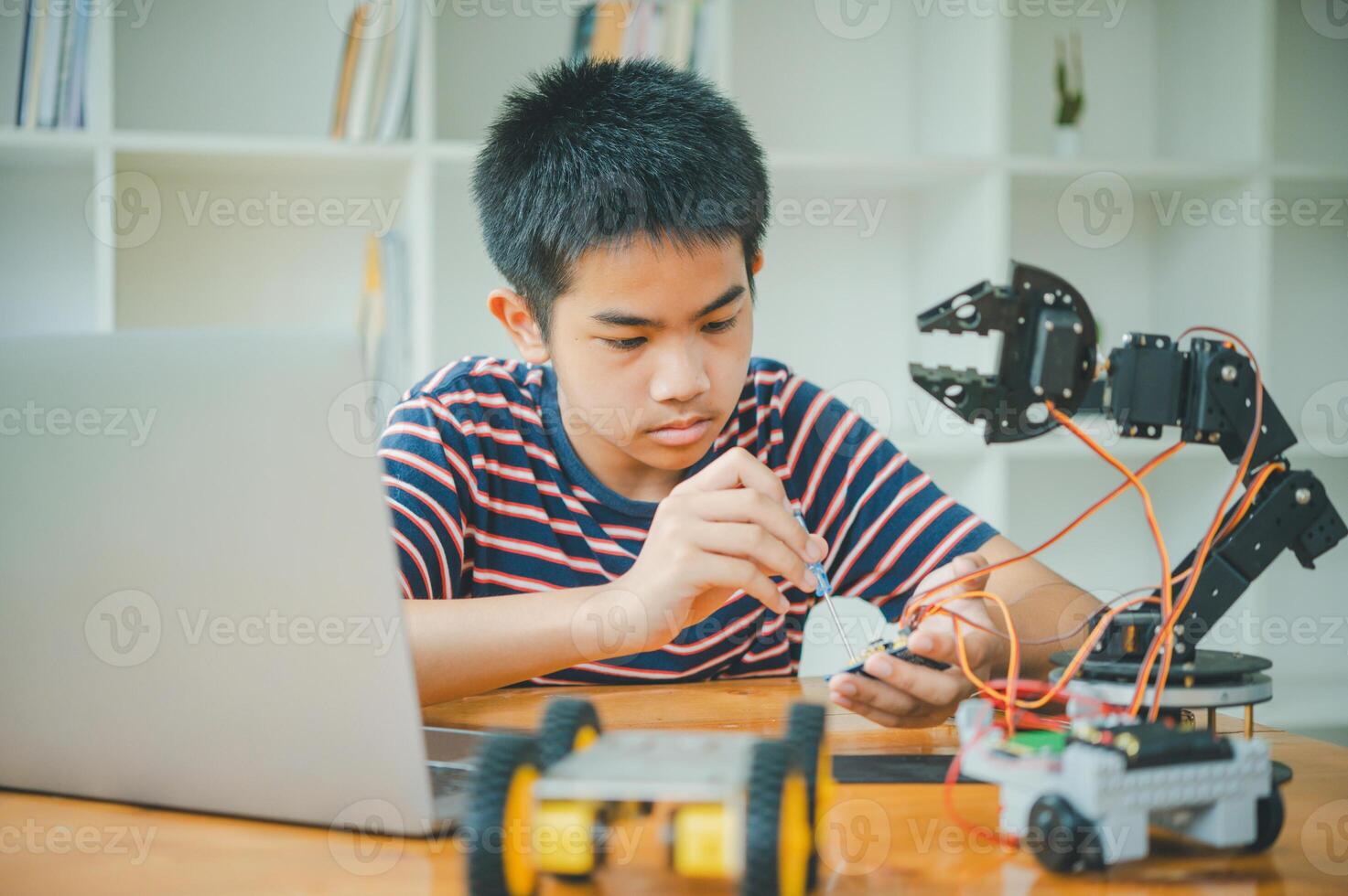 Asian boy learning and studying the work of technology robots.homeschool and science for tech project. playing childhood kids hobby leisure lifestyle people toys robotics technology. photo