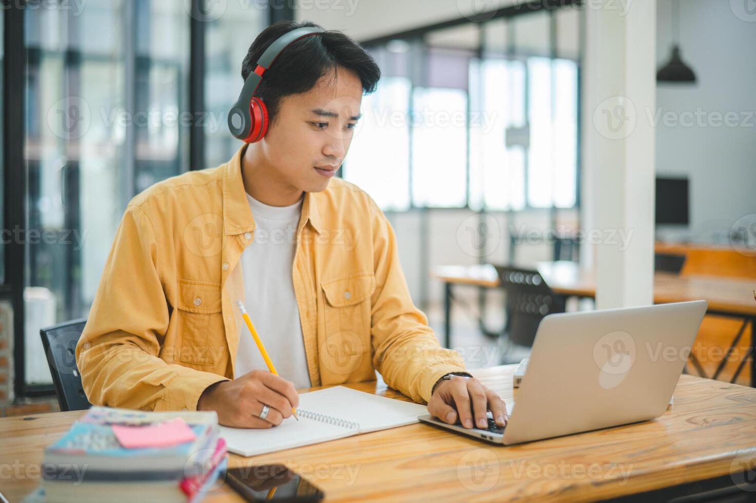 Young Asian college student working and learning on laptop In the cafe. Searching for knowledge online. photo