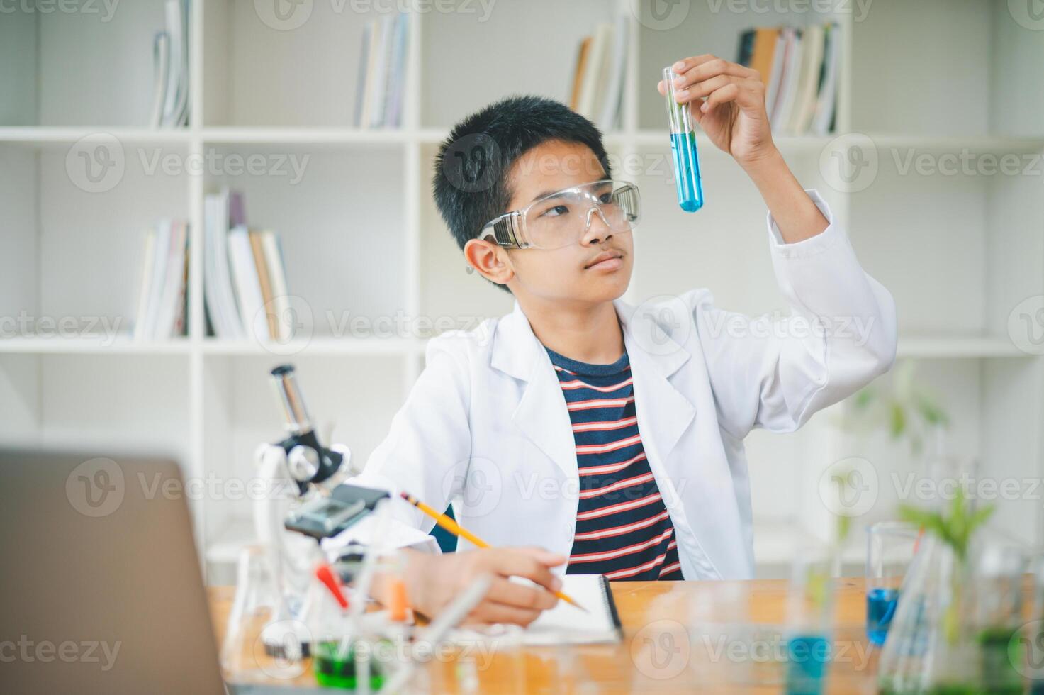 Asian male science students looking through a microscope and tests of plants in the classroom. Learning about scientific experiments on plant species. photo