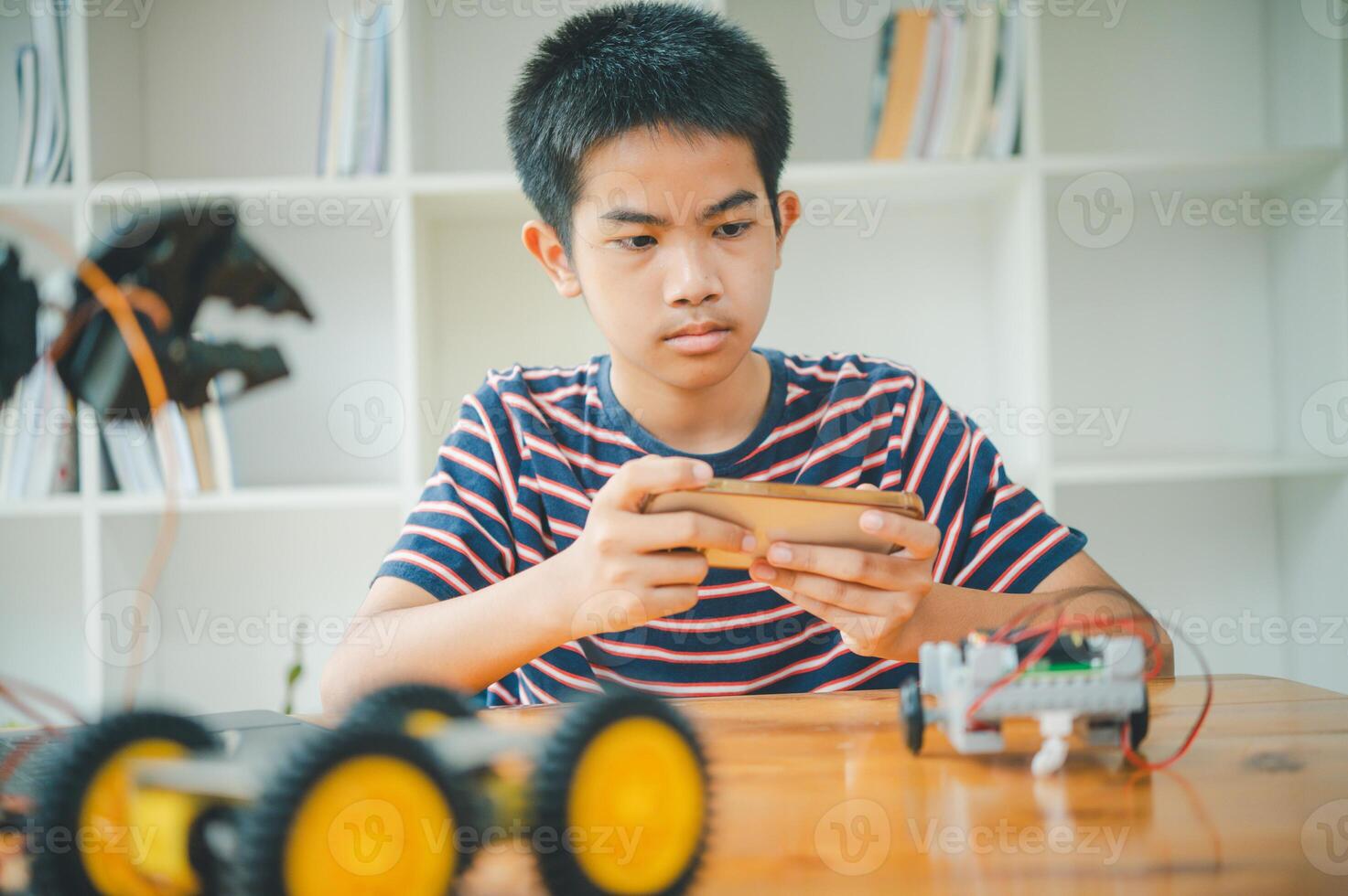 Asian boy learning and studying the work of technology robots.homeschool and science for tech project. playing childhood kids hobby leisure lifestyle people toys robotics technology. photo
