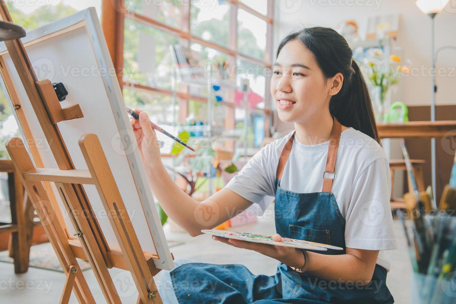 Art student drawing with watercolor painting on canvas doing some art projects on studio workshop photo