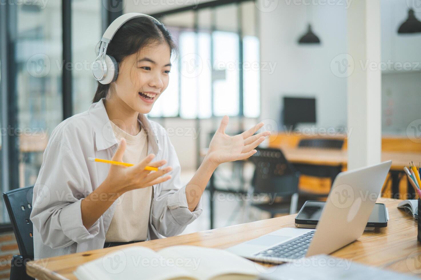 Teenage Asian students wearing a headphone are communicating through conferencing for online learning. In a conference call via apps. photo