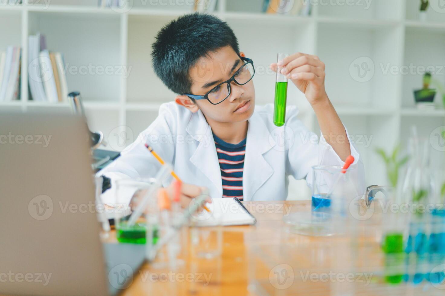 Asian male science students looking through a microscope and tests of plants in the classroom. Learning about scientific experiments on plant species. photo