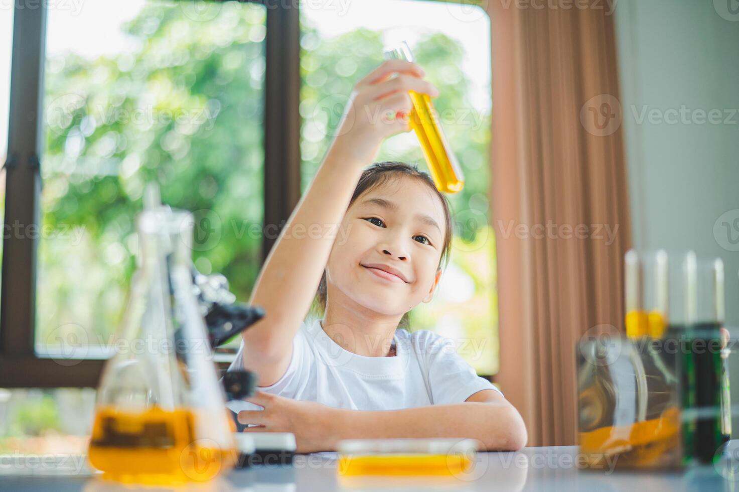 little scientist looking through a microscope and test tubes filled with chemicals for learning about science and experiments. photo