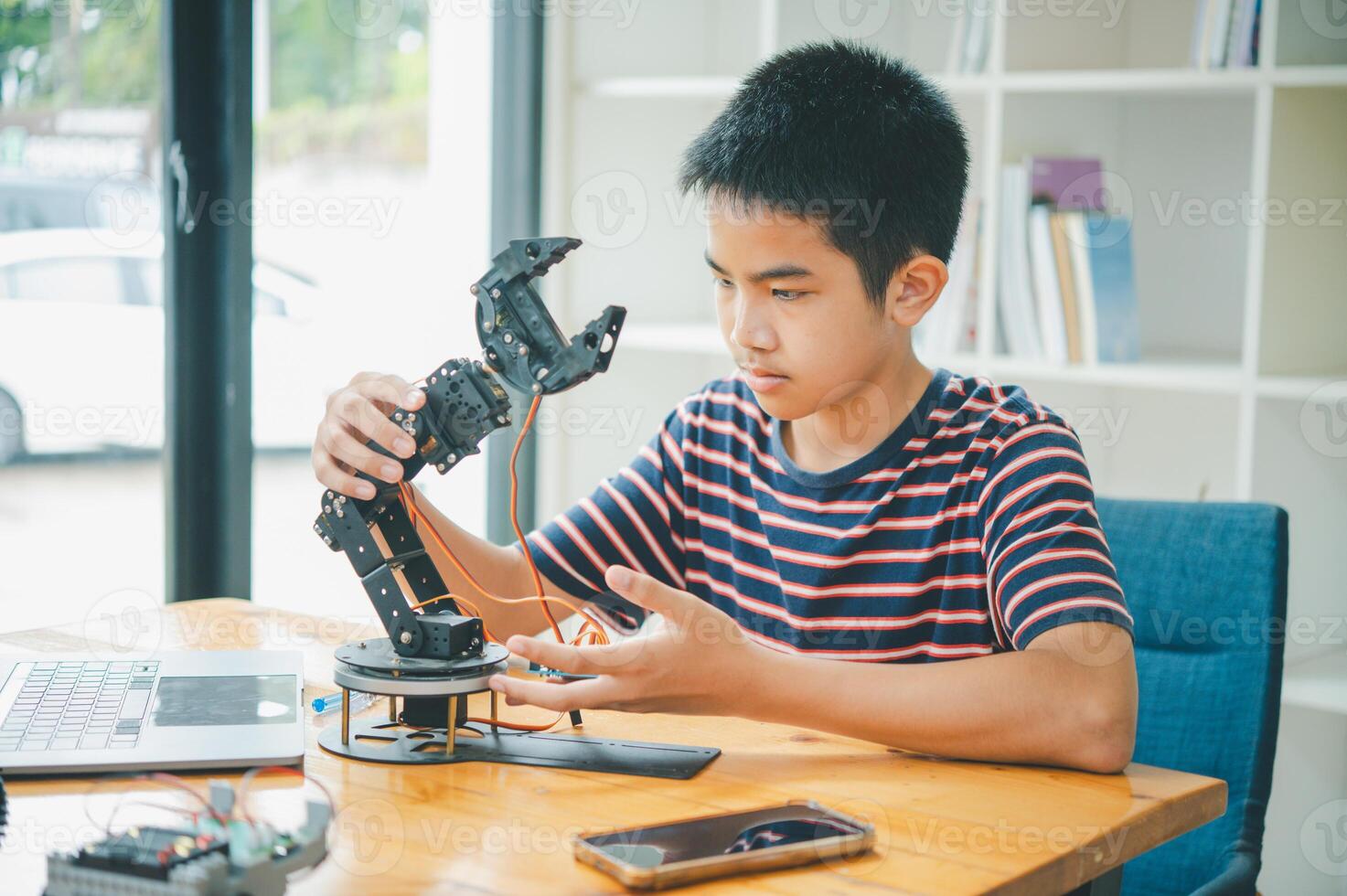 Asian boy learning and studying the work of technology robots.homeschool and science for tech project. playing childhood kids hobby leisure lifestyle people toys robotics technology. photo