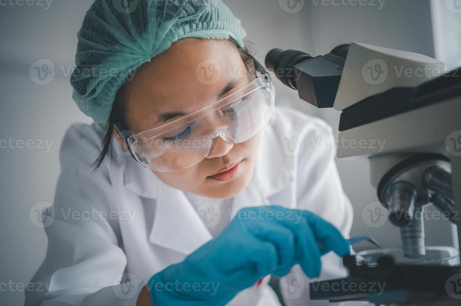 Female researchers are experimenting with pipette dropping a sample into a test tube in an experiment research in laboratory.. photo