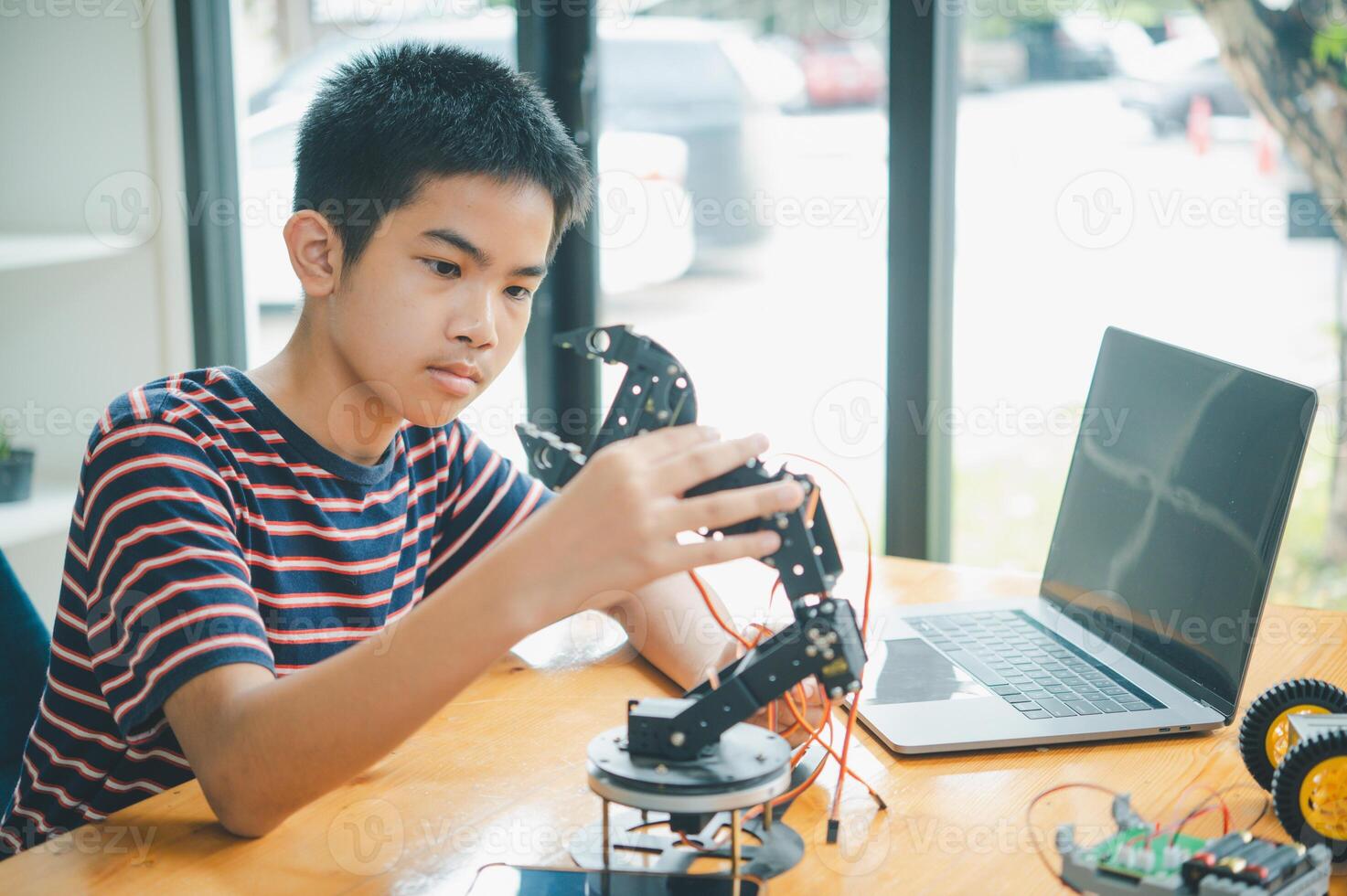 Asian boy learning and studying the work of technology robots.homeschool and science for tech project. playing childhood kids hobby leisure lifestyle people toys robotics technology. photo