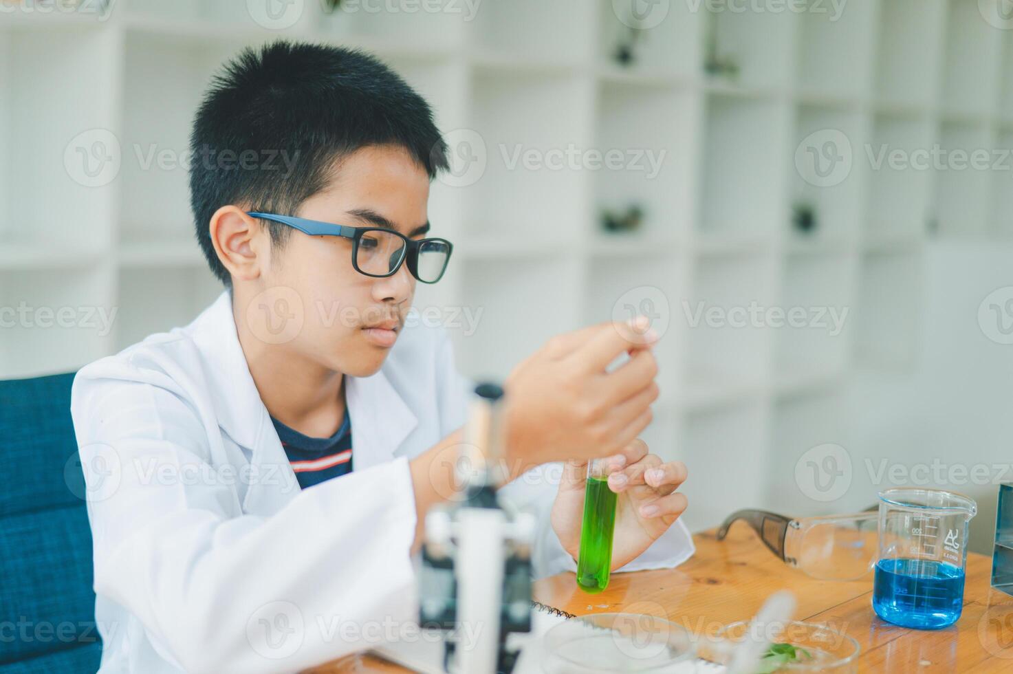 Asian male science students looking through a microscope and tests of plants in the classroom. Learning about scientific experiments on plant species. photo