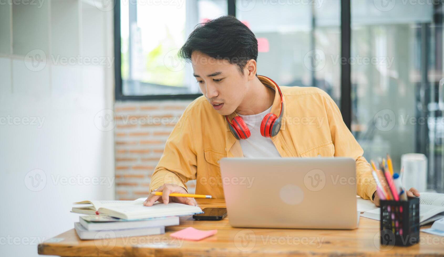 Young Asian college student working and learning on laptop In the cafe. Searching for knowledge online. photo