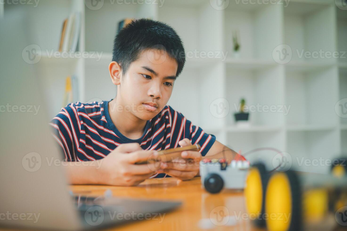 Asian boy learning and studying the work of technology robots.homeschool and science for tech project. playing childhood kids hobby leisure lifestyle people toys robotics technology. photo