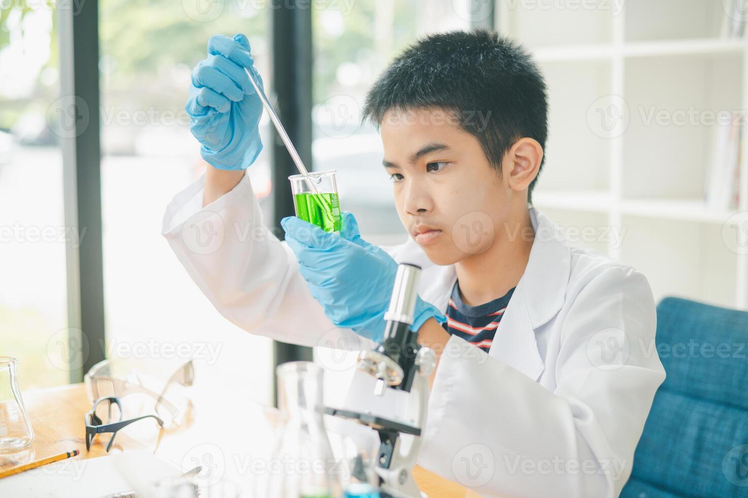 Asian male science students looking through a microscope and tests of plants in the classroom. Learning about scientific experiments on plant species. photo