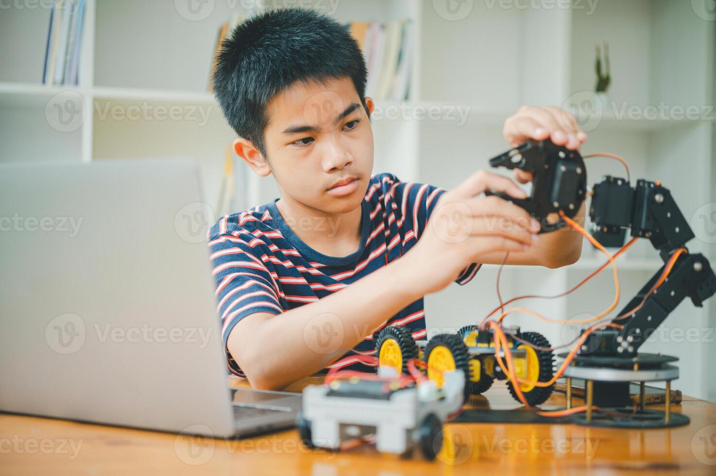 Asian boy learning and studying the work of technology robots.homeschool and science for tech project. playing childhood kids hobby leisure lifestyle people toys robotics technology. photo