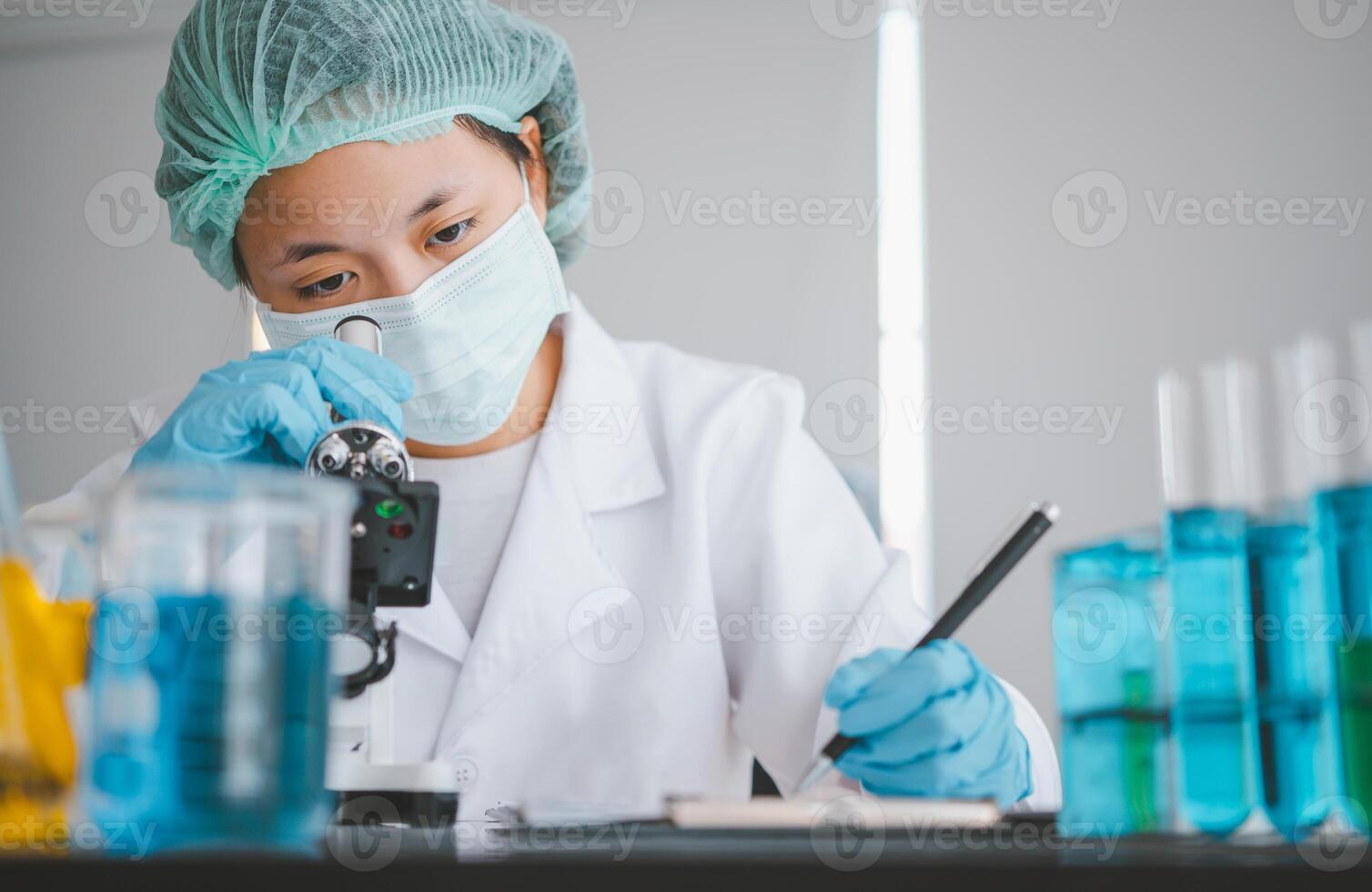 Female researchers are experimenting with pipette dropping a sample into a test tube in an experiment research in laboratory.. photo