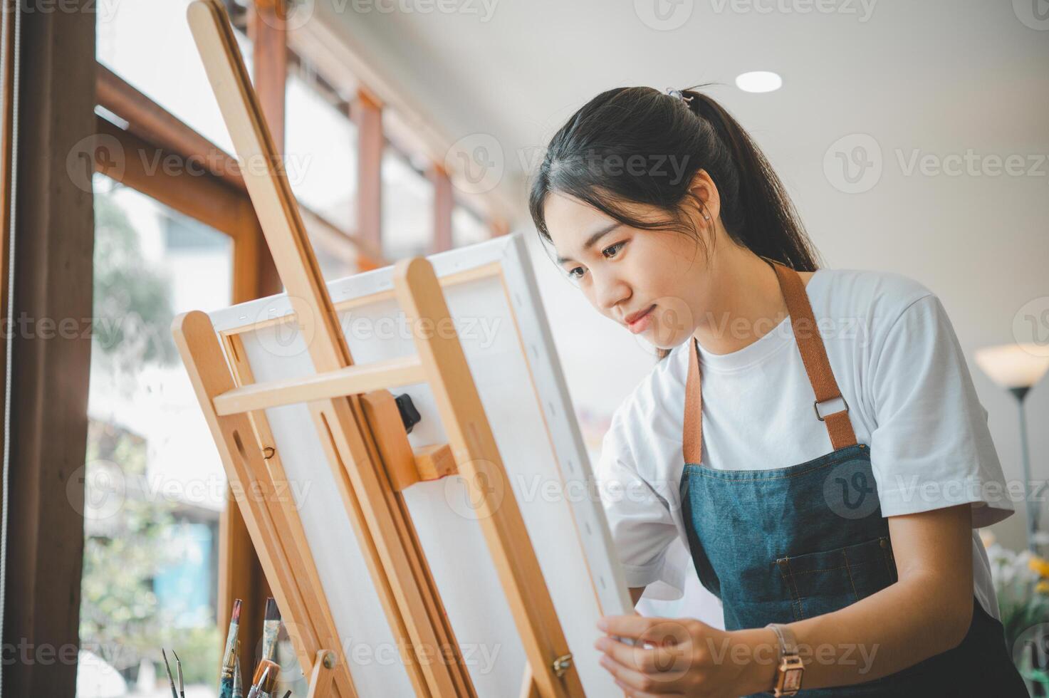 Art student drawing with watercolor painting on canvas doing some art projects on studio workshop photo