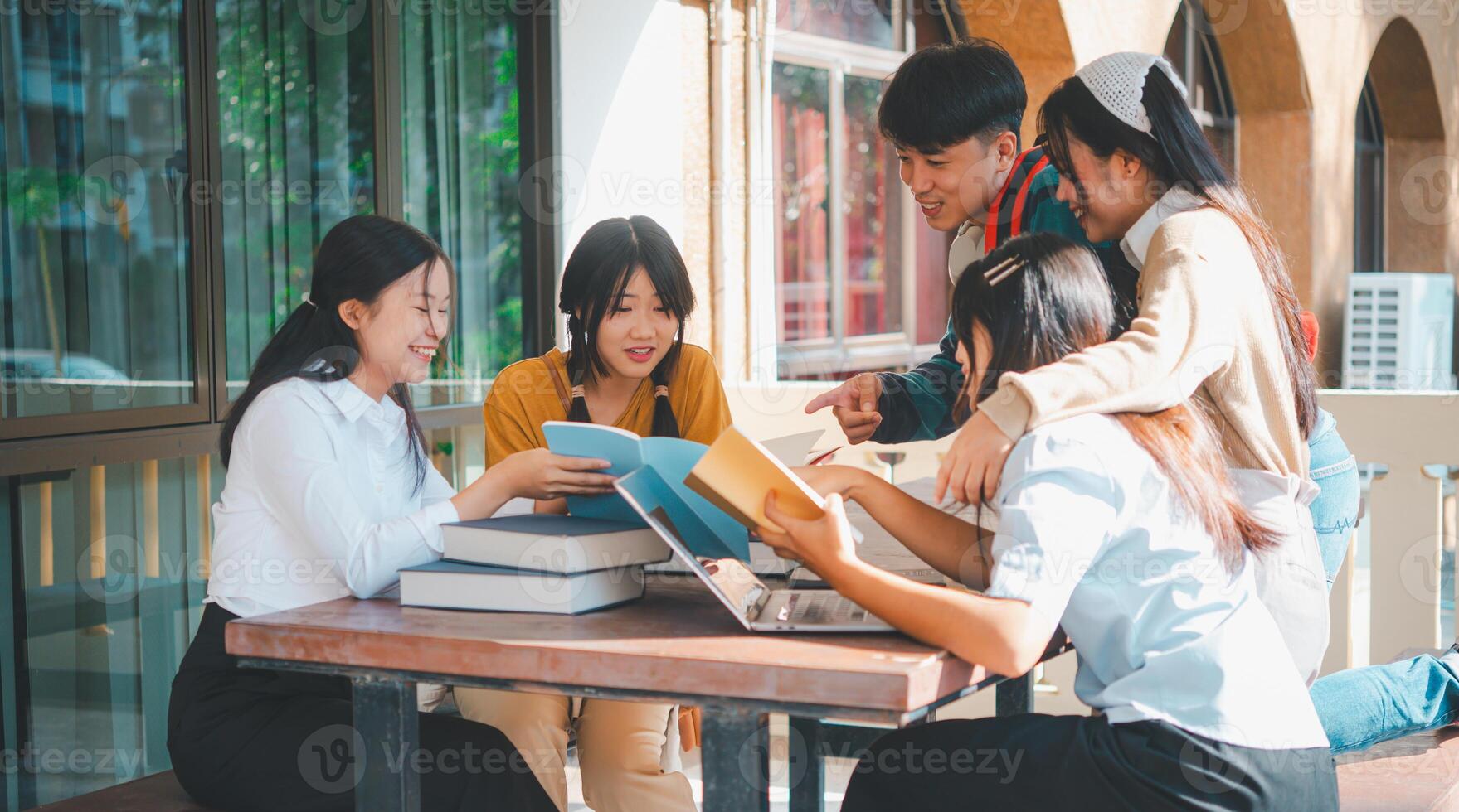 group of students young university students consulting doing homework, cooperating research plan Discuss concepts and strategies. Prepare presentations on laptops and tablet computers. photo