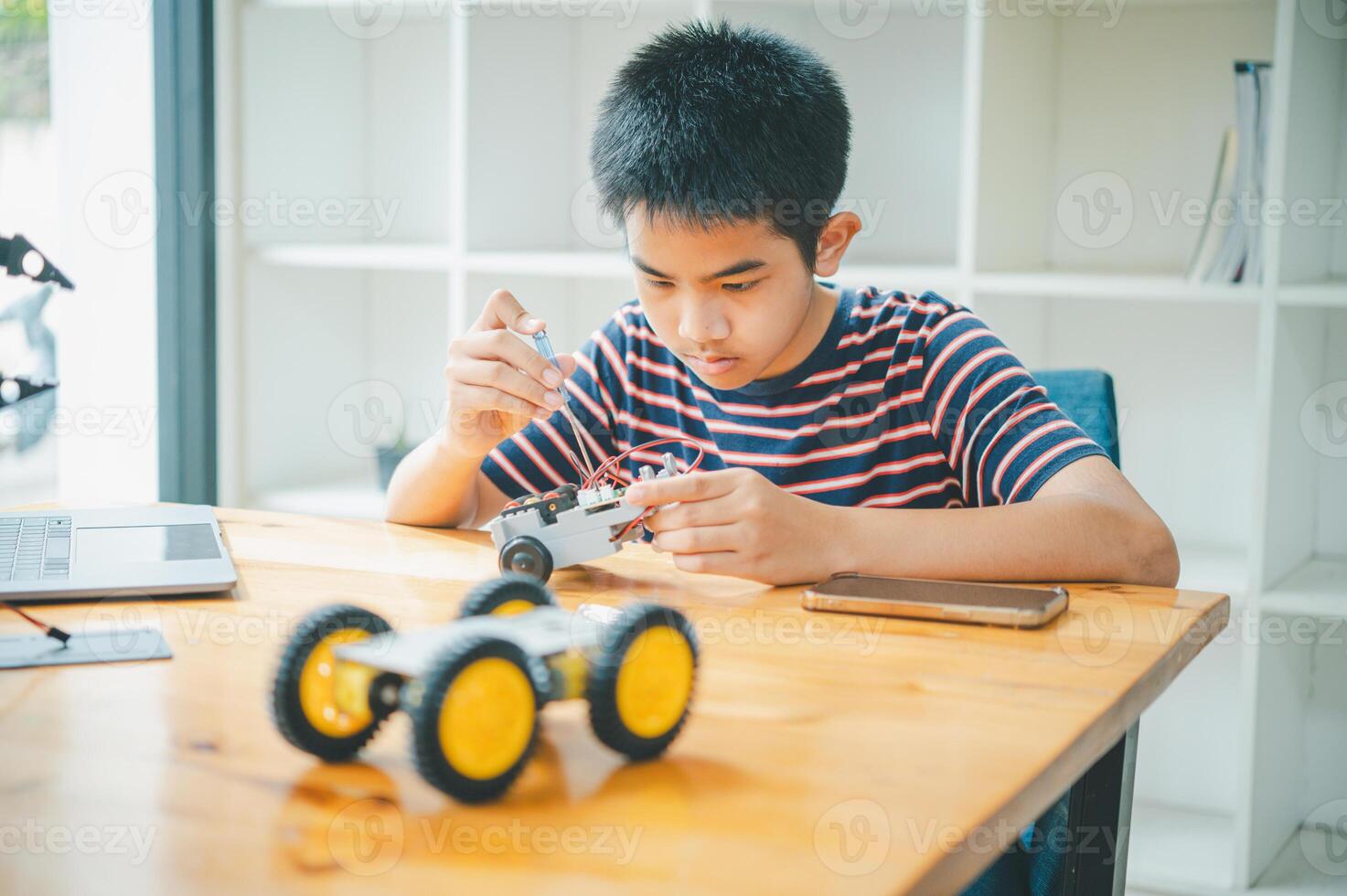 Asian boy learning and studying the work of technology robots.homeschool and science for tech project. playing childhood kids hobby leisure lifestyle people toys robotics technology. photo