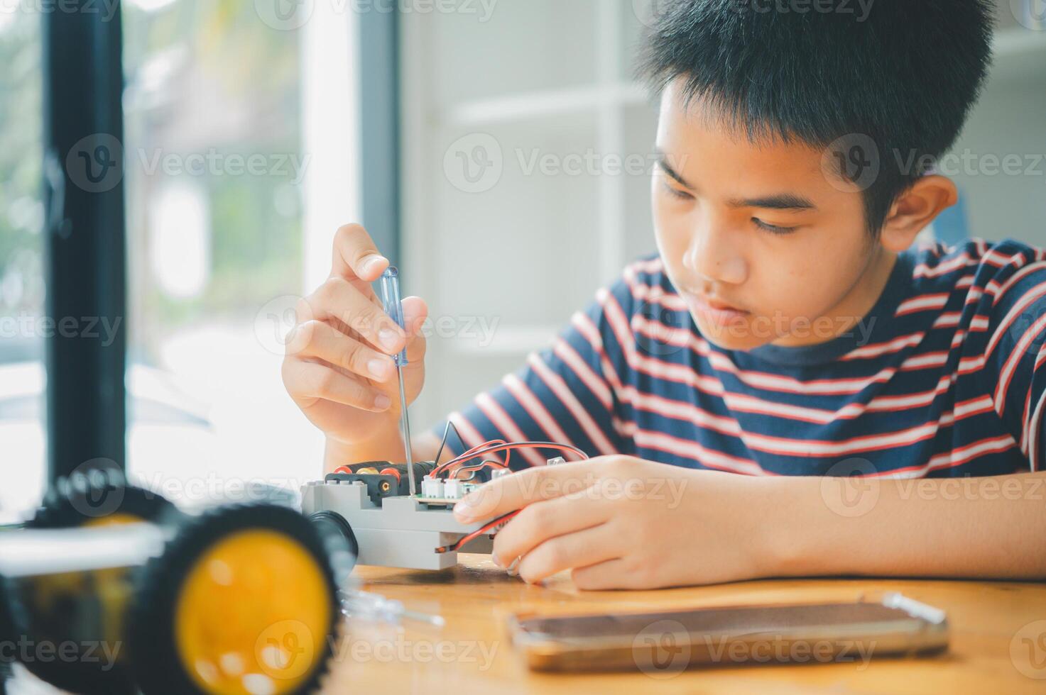 Asian boy learning and studying the work of technology robots.homeschool and science for tech project. playing childhood kids hobby leisure lifestyle people toys robotics technology. photo