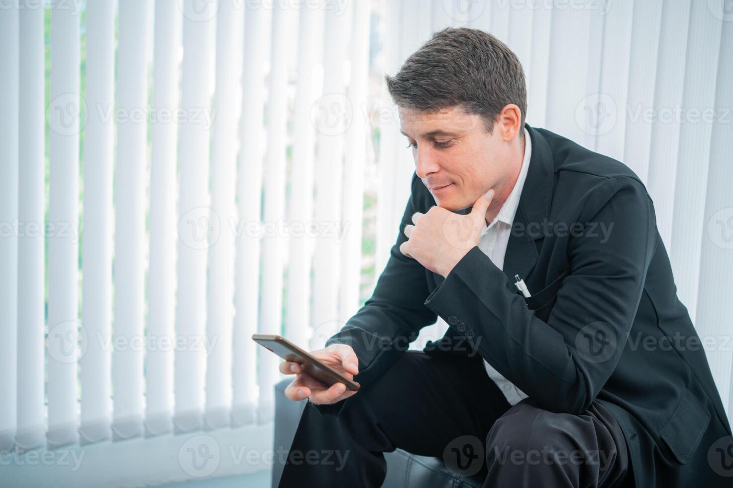Businessman working on the phone touching the screen, browsing the internet or writing text messages. photo