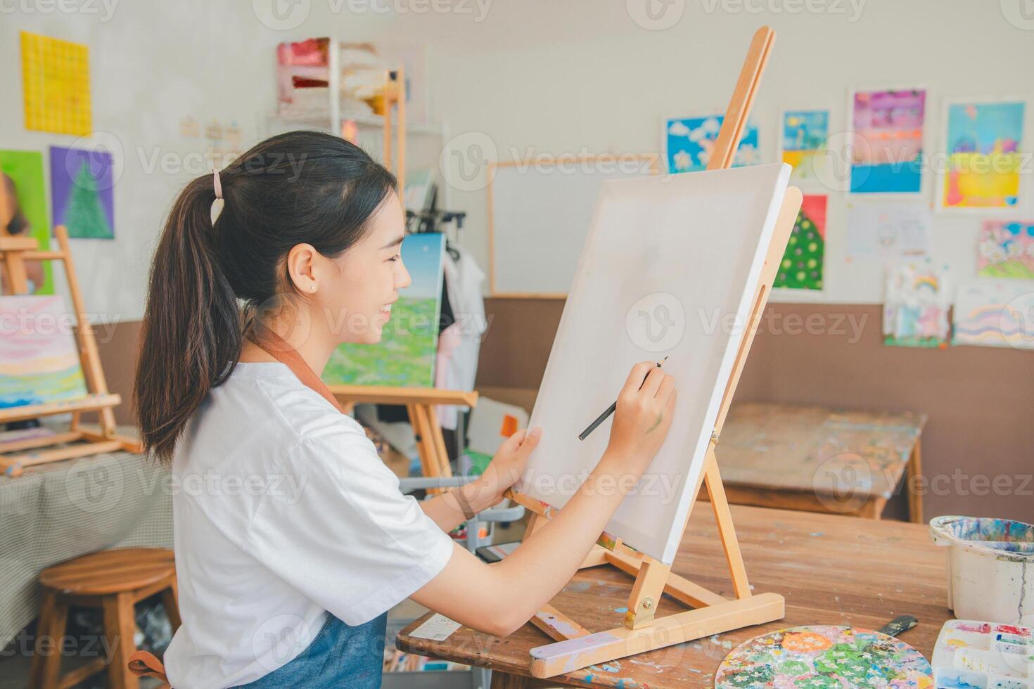 Art student drawing with watercolor painting on canvas doing some art projects on studio workshop photo