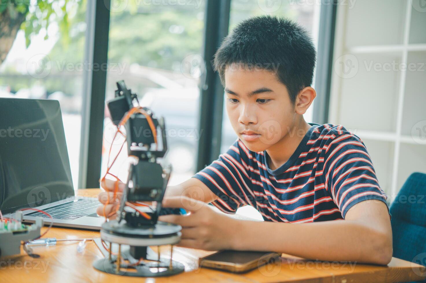 Asian boy learning and studying the work of technology robots.homeschool and science for tech project. playing childhood kids hobby leisure lifestyle people toys robotics technology. photo