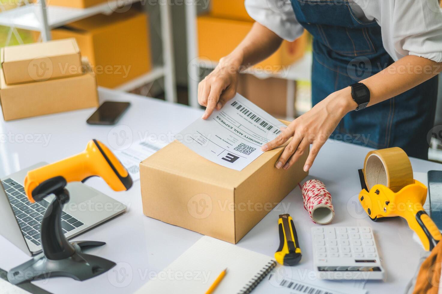 startup young female small business owners attaching shipping labels to cardboard boxes or parcels for delivery of customer orders-concept shopping online photo