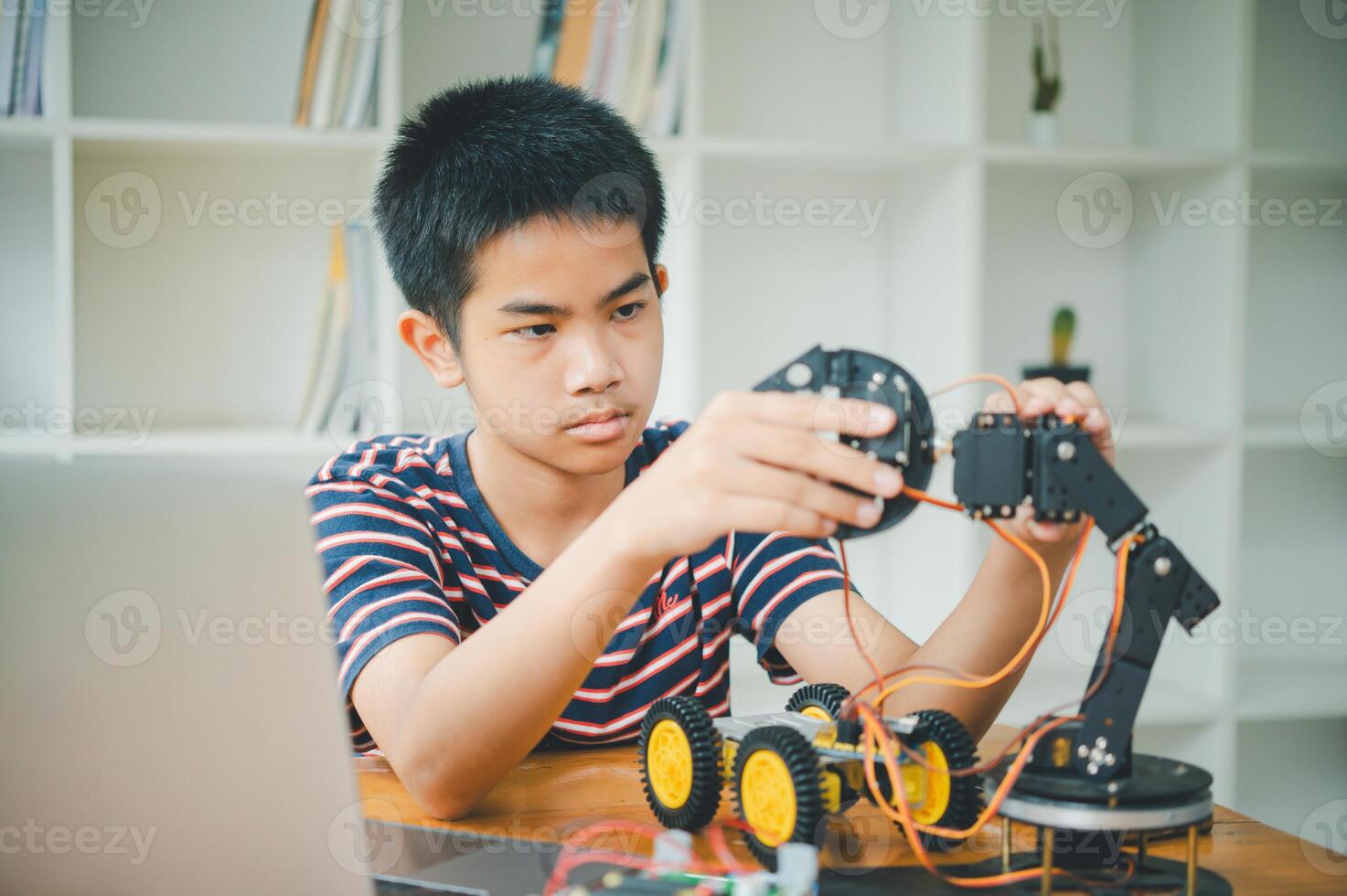 Asian boy learning and studying the work of technology robots.homeschool and science for tech project. playing childhood kids hobby leisure lifestyle people toys robotics technology. photo
