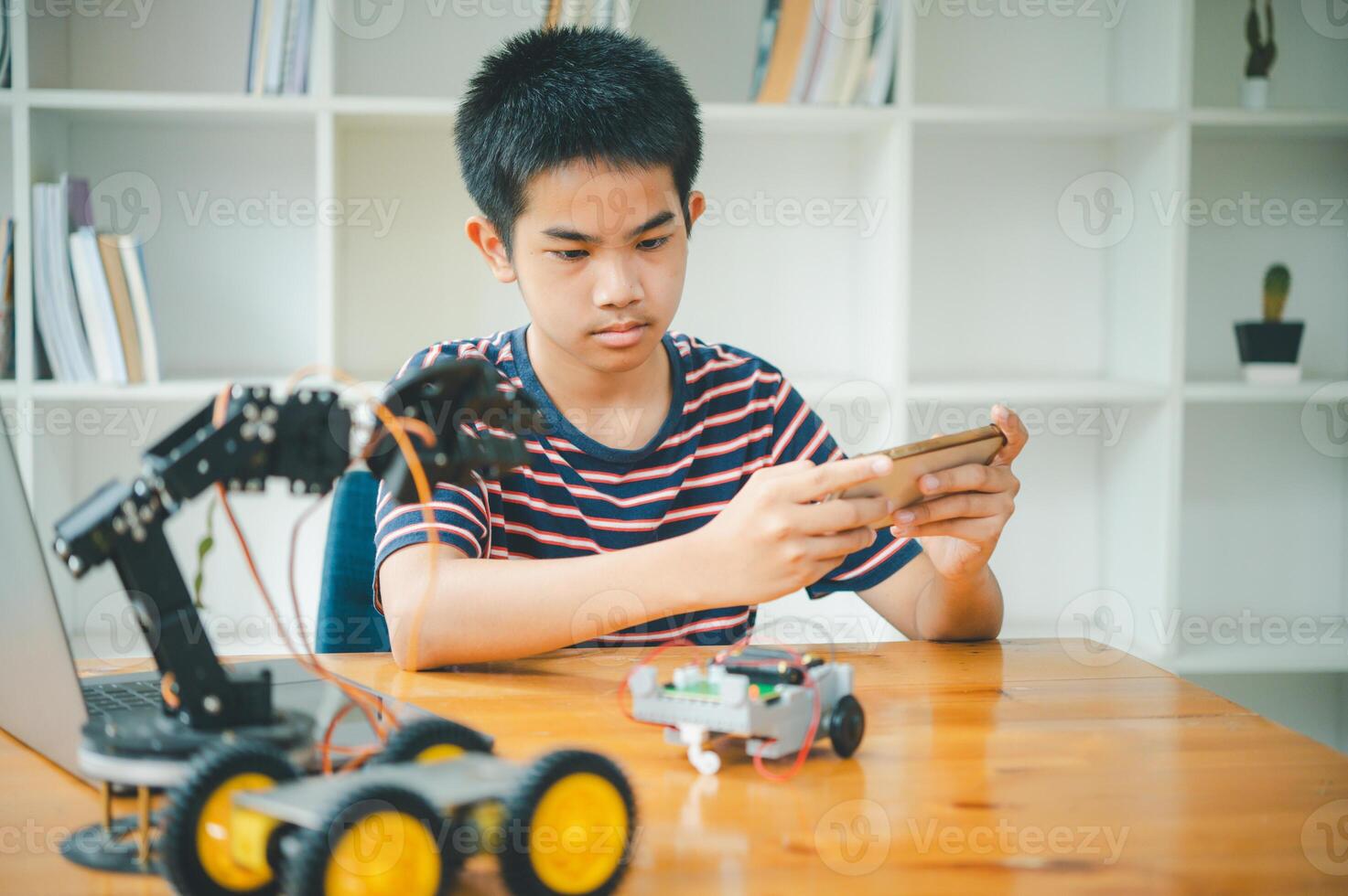 Asian boy learning and studying the work of technology robots.homeschool and science for tech project. playing childhood kids hobby leisure lifestyle people toys robotics technology. photo