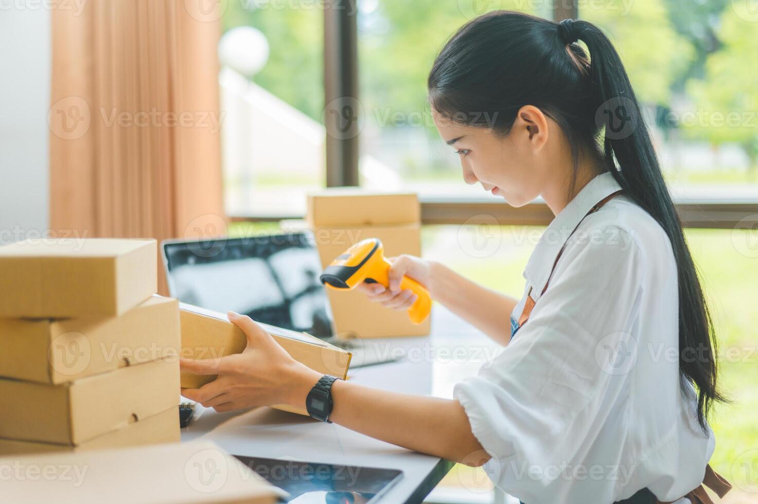 online small business owner scans a barcode-labeled parcel with a barcode scanner to verify a customer's order before it is delivered to the customer. photo