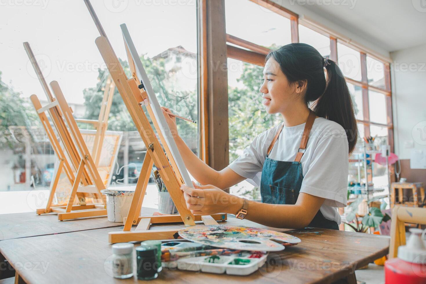 Art student drawing with watercolor painting on canvas doing some art projects on studio workshop photo