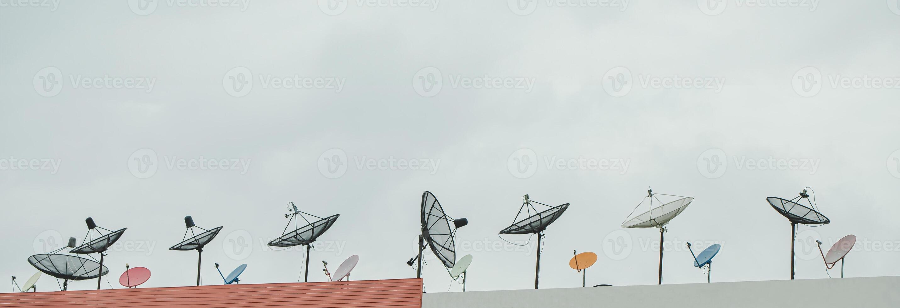 Many old communication satellite dishes expired and left on rooftops. photo