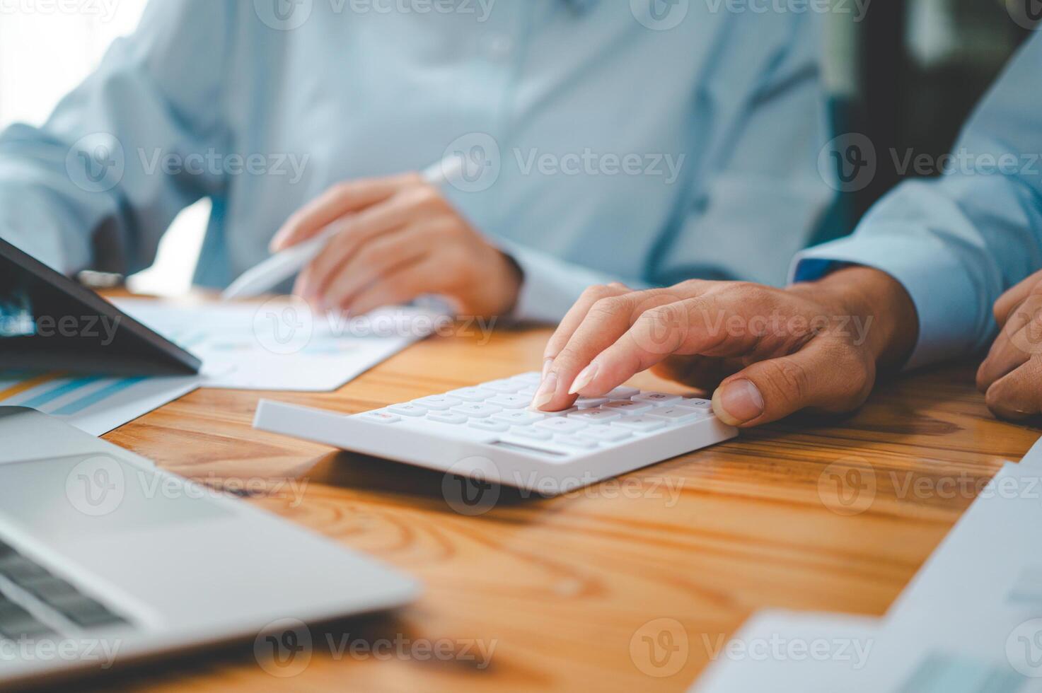 close up The business person is sitting on a calculator with a graph in the office of finance accounting concept photo