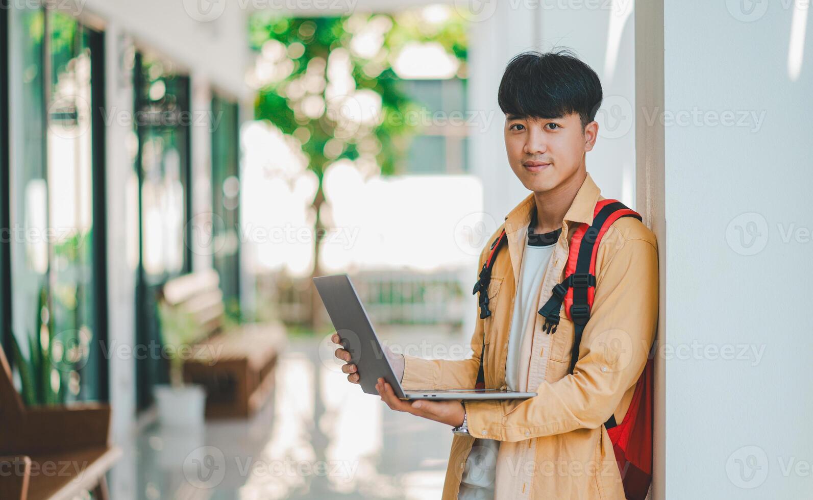 Happy smiling student with book in hand on campus while going to study for learning. photo