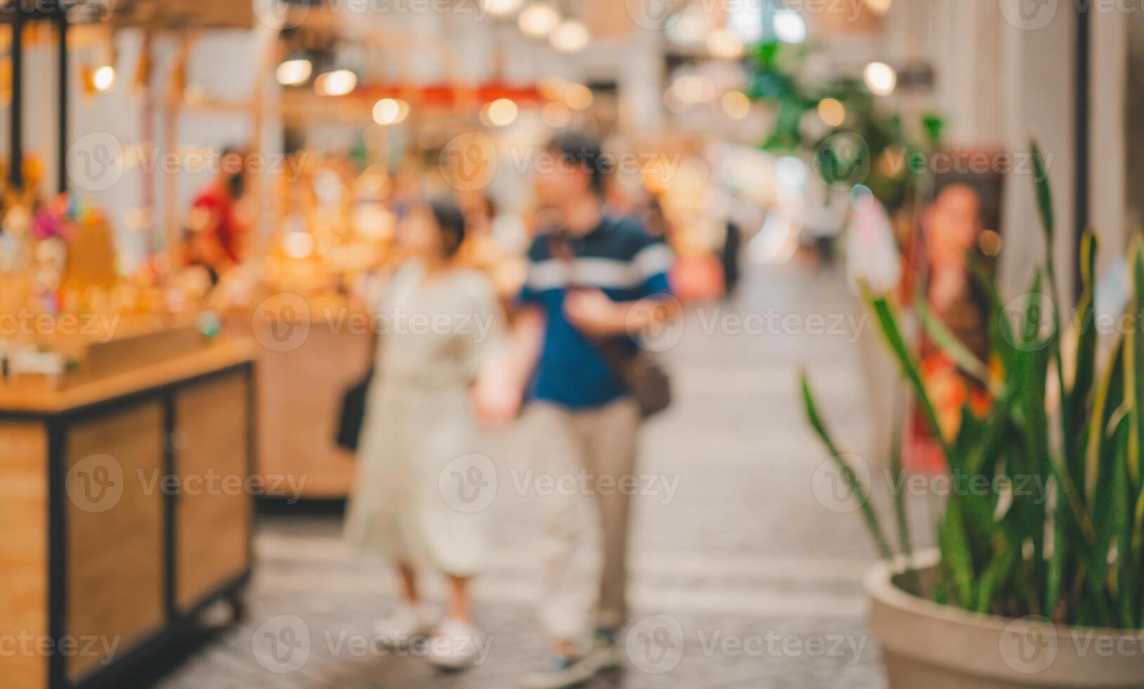 A blurry image of a couple walking down a street with a plant in a pot photo