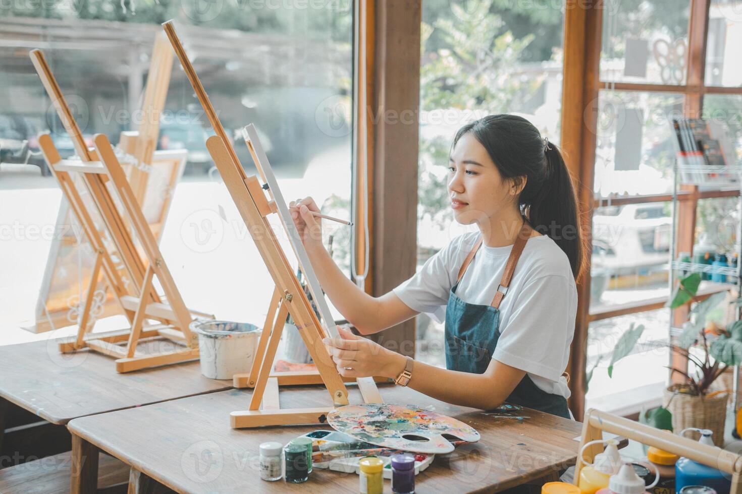 Art student drawing with watercolor painting on canvas doing some art projects on studio workshop photo