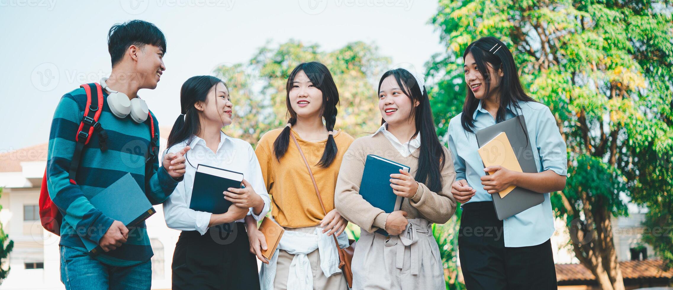 A group of young people are smiling and holding books photo