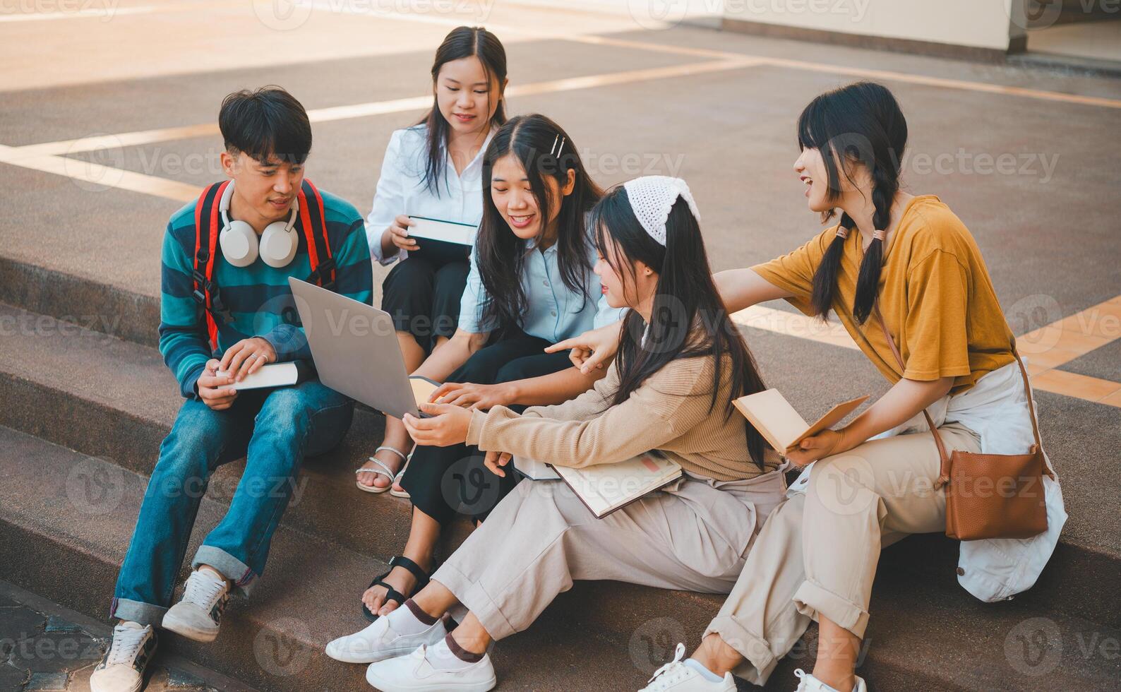 group of students young university students consulting doing homework, cooperating research plan Discuss concepts and strategies. Prepare presentations on laptops and tablet computers. photo