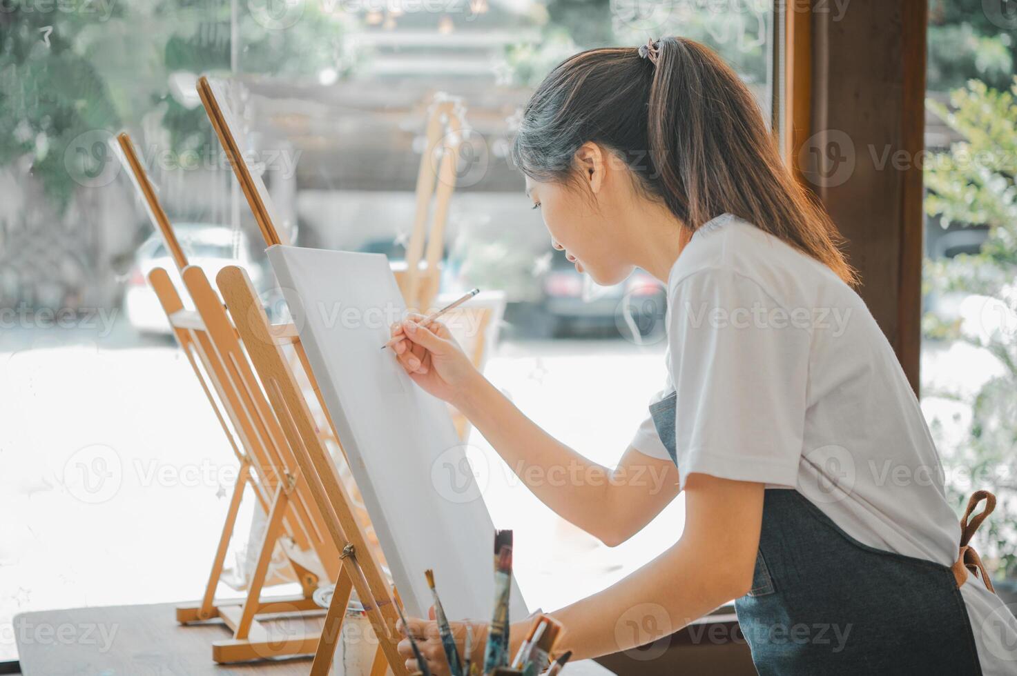Art student drawing with watercolor painting on canvas doing some art projects on studio workshop photo