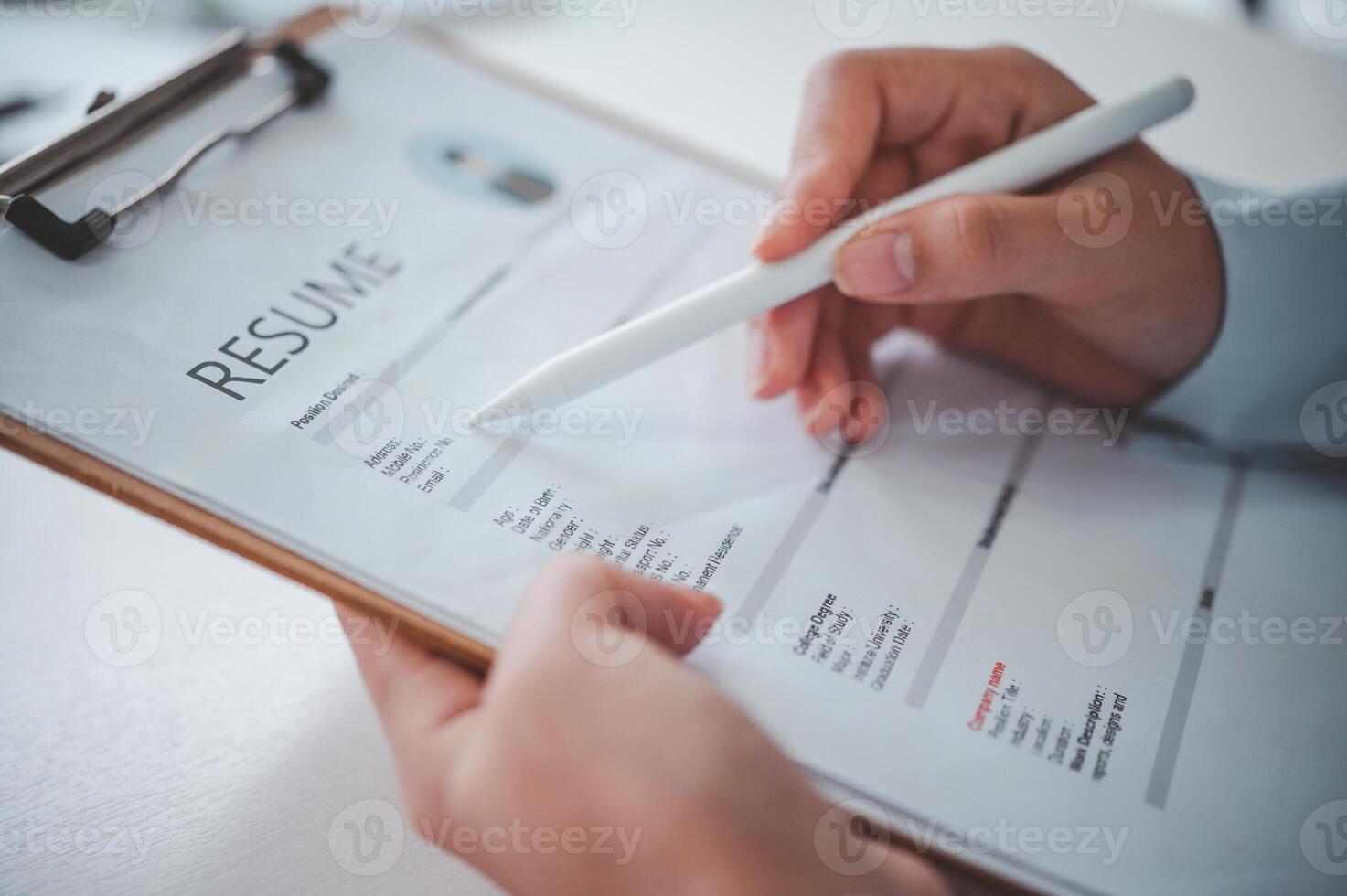 People are reviewing job applications before filling out their resume on the job application form in order to apply for a job at a company. photo