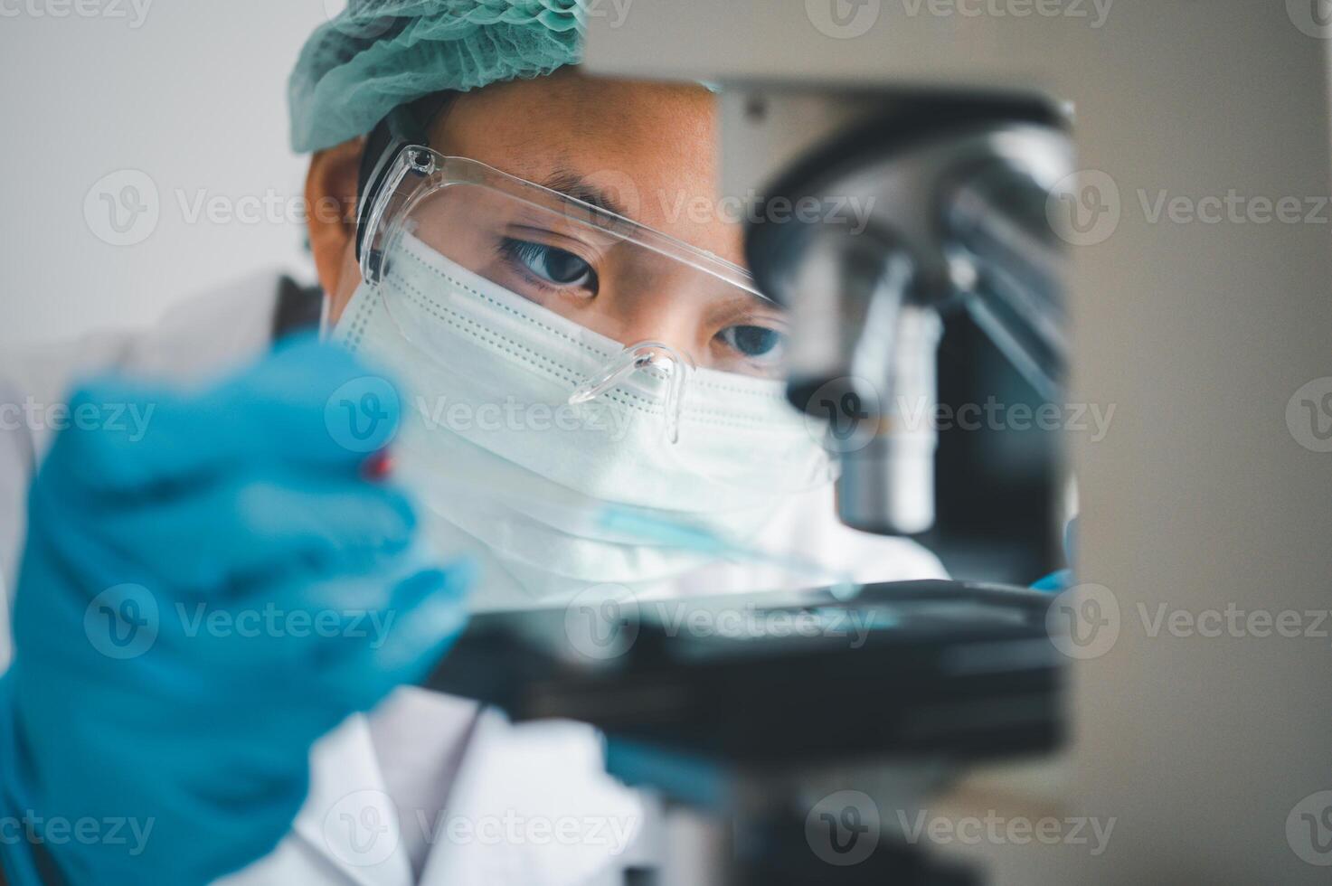 Female researchers are experimenting with pipette dropping a sample into a test tube in an experiment research in laboratory.. photo