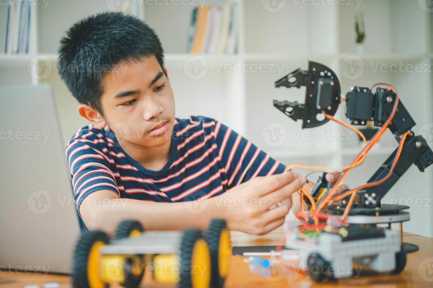 Asian boy learning and studying the work of technology robots.homeschool and science for tech project. playing childhood kids hobby leisure lifestyle people toys robotics technology. photo